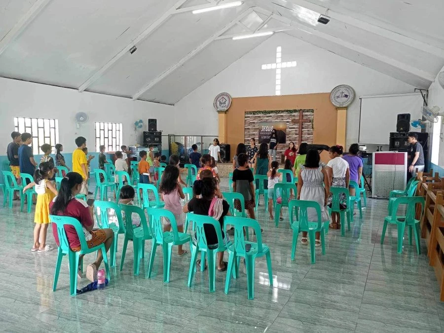 Families and children attending a community gathering in a church hall