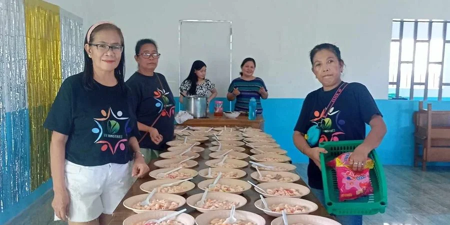 Volunteers preparing meals together for a community program